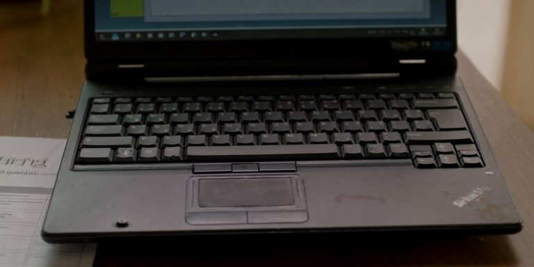 Running laptops past refresh date: worn business laptop close-up on a Navi Mumbai office desk, Sirius Star
