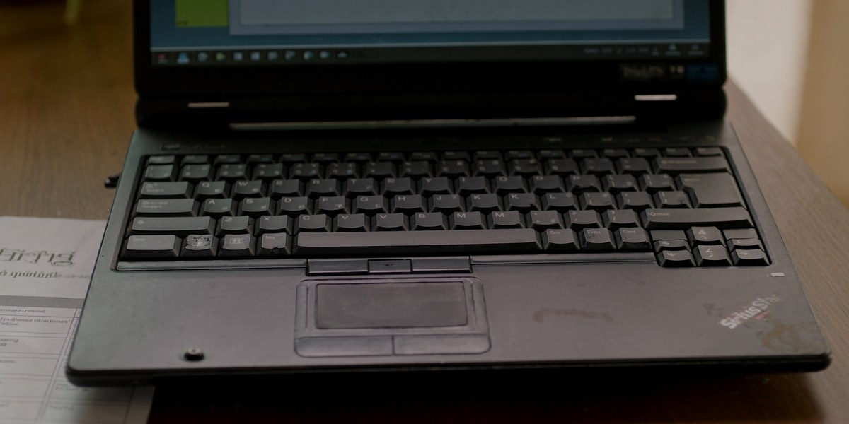 Running laptops past refresh date: worn business laptop close-up on a Navi Mumbai office desk, Sirius Star