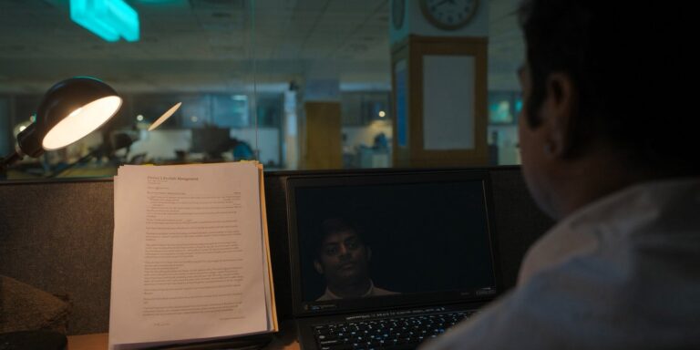 DLM with in-house IT, an Indian IT manager reviewing a Device Lifecycle Management contract at his Navi Mumbai desk, Sirius Star