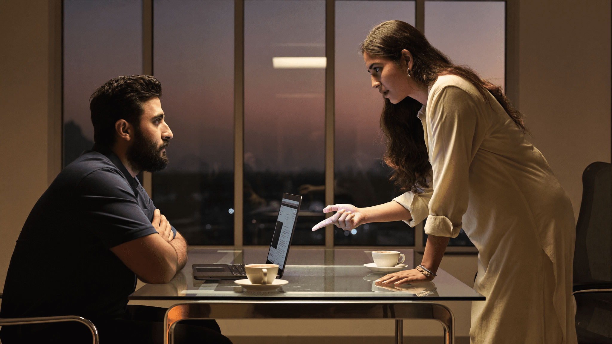 Indian CTO and M365 admin debating Microsoft Purview vs Microsoft 365 DLP across a boardroom table Friday evening