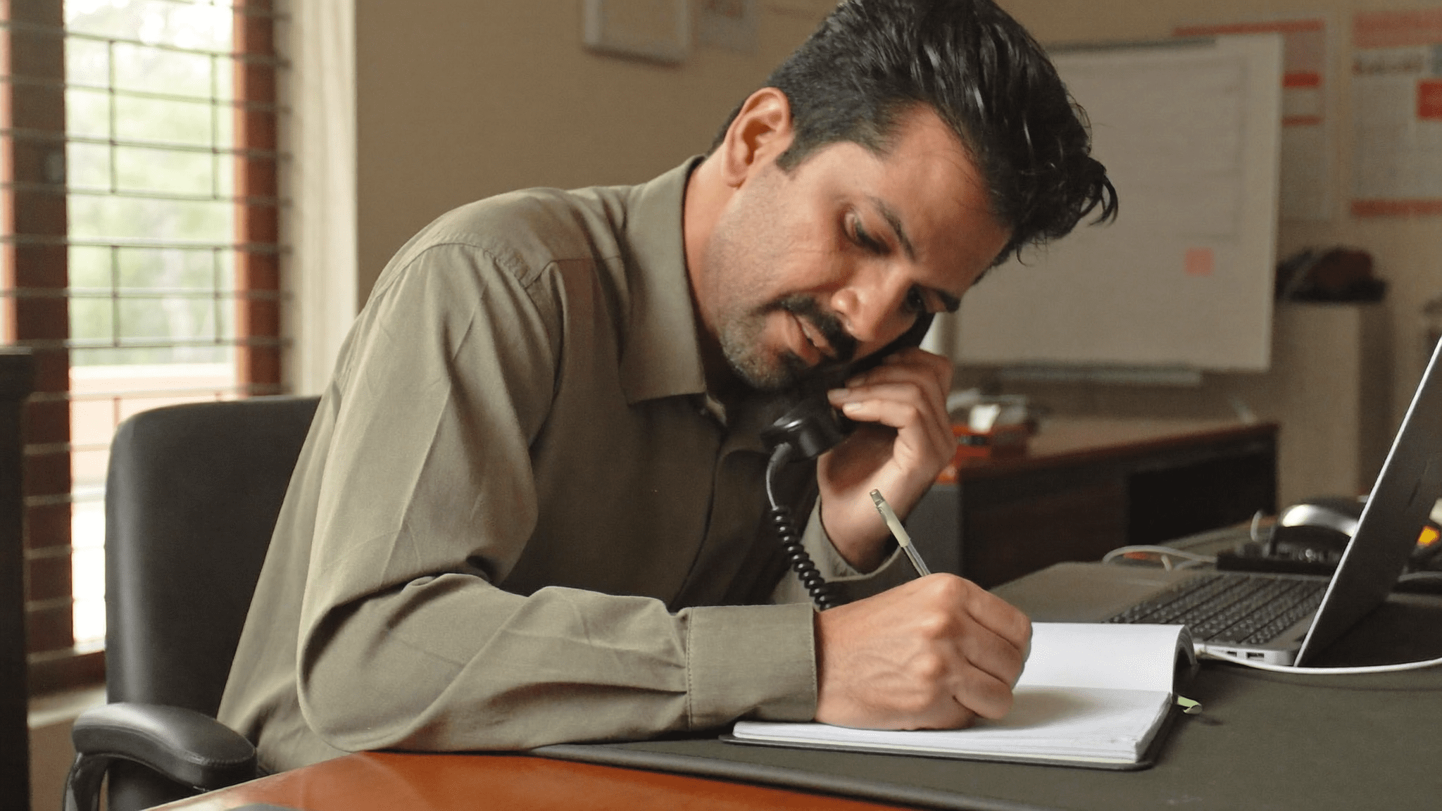 Indian CTO taking notes on phone call with Microsoft Purview implementation partner Monday morning Mumbai office