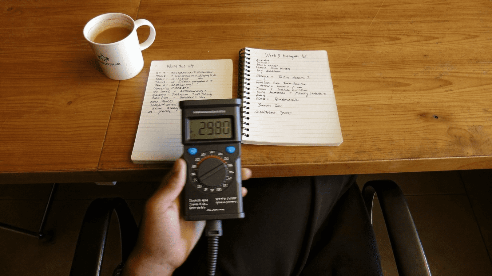 Digital lux meter reading 2480 lux on training room table beside week 8 brightness test log, BenQ bake-off
