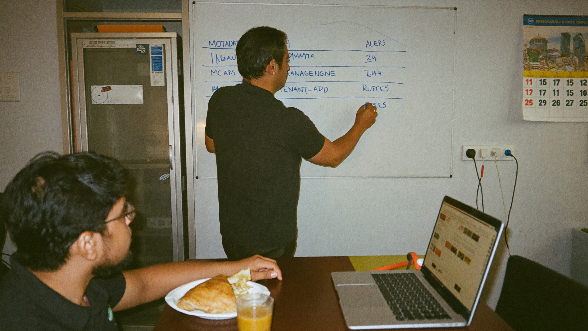 Pune MSP operations manager annotating a whiteboard comparison of Motadata vs ManageEngine OpManager Plus vs SolarWinds