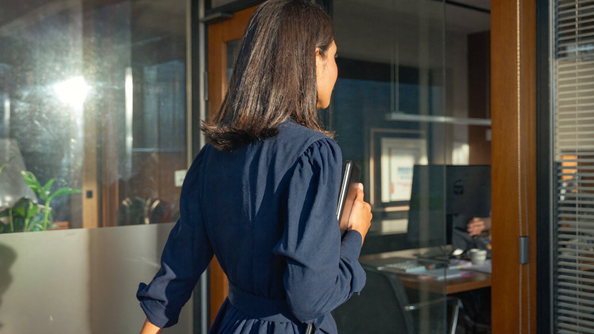 Indian HR head walking into Bengaluru office meeting room with tablet morning light