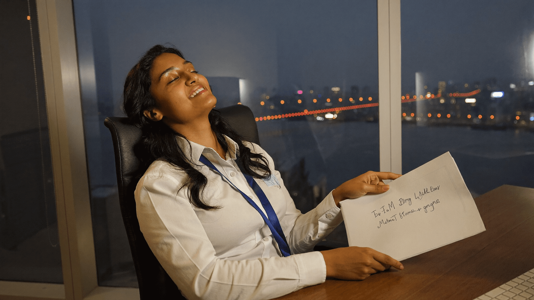 Indian IT manager leaning back in chair at desk evening relief eyes closed faint smile