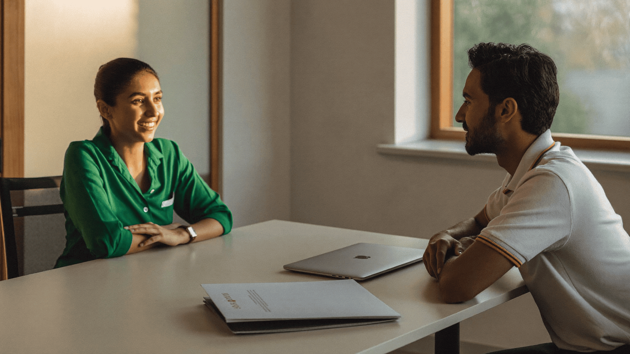 HR manager explaining a CTC device leasing benefit to a young employee across a table with a laptop, in a Navi Mumbai office